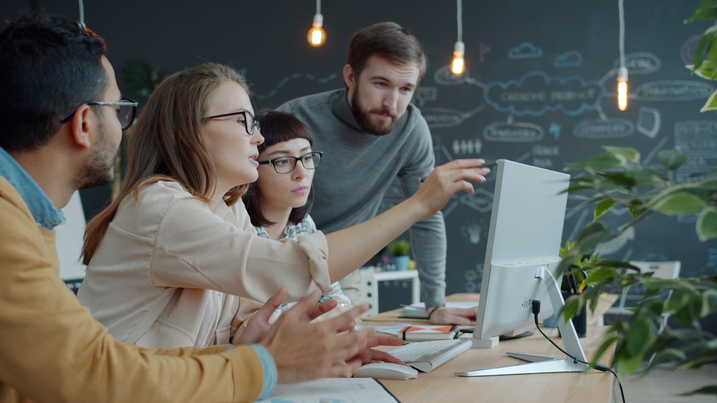Team werkt samen achter een laptop op kantoor